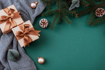 Christmas composition with gifts, pine branches and decorations on green background. Top view, flat lay, copy space