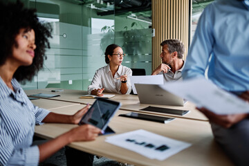 Portrait of young businesswoman and mid aged businessman having a meeting or presentation and...