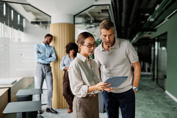 Portrait of young businesswoman and businessman using a tablet having a meeting or presentation and seminar in the office