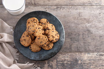 Chocolate chip cookies and milk for breakfast on rustic wooden table. Top view. Copy space