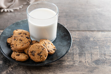 Chocolate chip cookies and milk for breakfast on rustic wooden table. Copy space