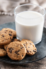 Chocolate chip cookies and milk for breakfast on rustic wooden table