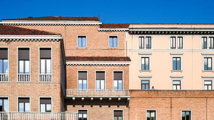 Ancient Venetian buildings close together reflecting in canal water