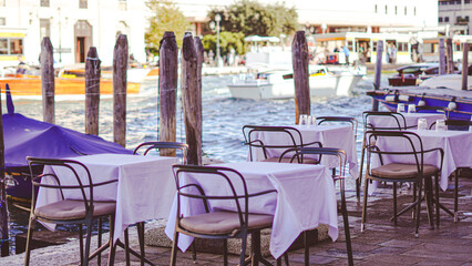 cozy outdoor cafe by venice canal with charming italian atmosphere.