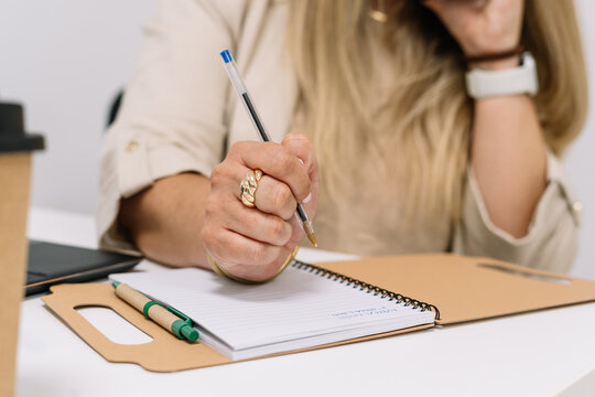 woman working in the office taking notes in a notebook