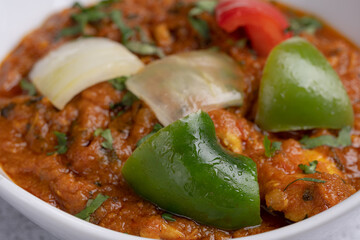 Chicken Karahi Curry – Authentic North Indian and Pakistani dish featuring tender chicken cooked in rich tomato gravy with onions, green and red bell peppers, and fresh herbs, served in a white bowl