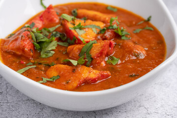 Chicken Tikka Masala Curry – Classic Indian curry with tender tandoori chicken pieces in a rich tomato and spice-infused masala sauce, garnished with fresh coriander, served in a white bowl