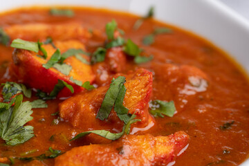 Chicken Tikka Masala Curry – Classic Indian curry with tender tandoori chicken pieces in a rich tomato and spice-infused masala sauce, garnished with fresh coriander, served in a white bowl
