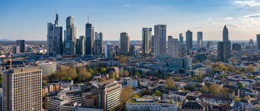 Aerial view of Frankfurt's skyline, where glass towers meet the awakening spring foliage in a dance of urban energy and natural rebirth, Frankfurt am Main, Hessen, Germany.
