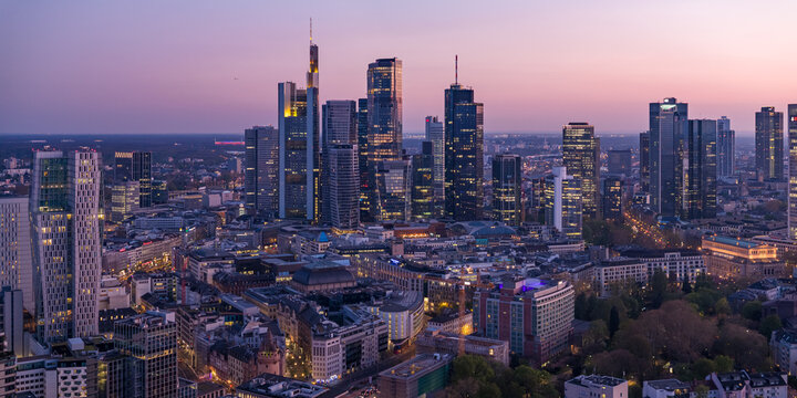Aerial view of the Main Tower and other skyscrapers piercing the twilight sky, casting long shadows over the city streets, Frankfurt am Main, Hessen, Germany.