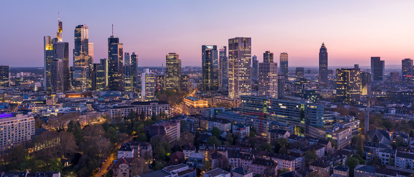 Aerial view of twinkling skyscrapers pierce the twilight sky above the illuminated streets and buildings of Frankfurt, Frankfurt am Main, Hessen, Germany.