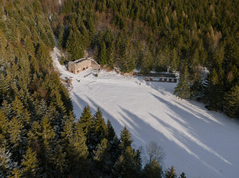 Aerial view of the Ludovika Stamp Mill, a relic amidst the snow-dusted forest, casting long shadows under the winter sun, Spania Dolina, Banska Bystrica Region, Slovakia.