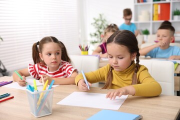 Children at wooden desks during art lesson in elementary school