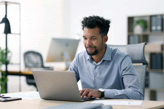 Man working on laptop at table in office