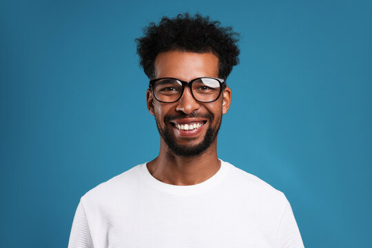 Portrait of happy man on light blue background
