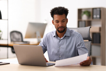 Man with document working at table in office