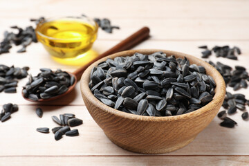 Sunflower seeds and oil on white wooden table, selective focus
