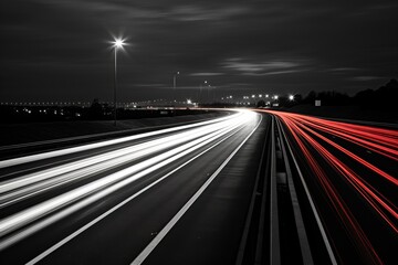 Obraz premium Long exposure of cars driving on highway at night creating white and red light trails