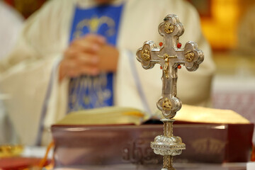 Holy Cross with Jesus Christ on the altar during the Holy Mass, the priest in the background
