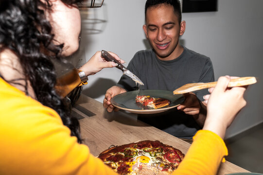 Smiling friends sharing pizza with affection and ease