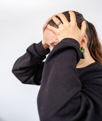 Close-up young girl holding head in pain, suffering from headache or stress, raw emotion, concept tension, human emotion, moments hurt, stress thinking, mental health, fatigue, emotional exhaustion