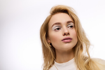 Naklejka premium Winter beauty with cozy knitted outfit and elegant makeup on a bright background