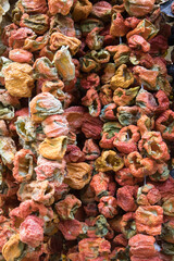 Strings of dried peppers hanging in dense garlands, rustic texture and warm tones; for food design, retail signage, packaging, recipe content.