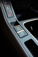 New car electric push pull handbrake button on the dashboard. Close up detail shot, no people
