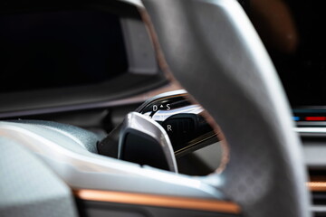 Small, steering column mounted automatic gearbox shifter lever on a new car. Close up shot, shallow depth of field, no people