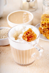 Tasty sweet and salted tahini honeycomb latte. Hot coffee drink with whipped non-dairy creamer, tahini sesame paste, honey and honeycomb garnish