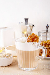 Tasty sweet and salted tahini honeycomb latte. Hot coffee drink with whipped non-dairy creamer, tahini sesame paste, honey and honeycomb garnish