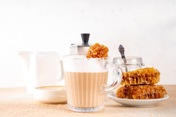 Tasty sweet and salted tahini honeycomb latte. Hot coffee drink with whipped non-dairy creamer, tahini sesame paste, honey and honeycomb garnish