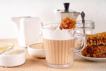 Tasty sweet and salted tahini honeycomb latte. Hot coffee drink with whipped non-dairy creamer, tahini sesame paste, honey and honeycomb garnish