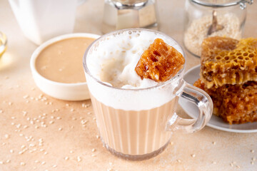 Tasty sweet and salted tahini honeycomb latte. Hot coffee drink with whipped non-dairy creamer, tahini sesame paste, honey and honeycomb garnish