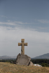 A Wooden Cross placed on a Stone amidst a Serene and Peaceful Landscape