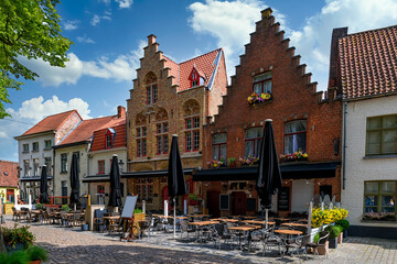Old street of the historic city center with tables of restaurant in Bruges (Brugge), West Flanders province, Belgium. Cityscape of Bruges.