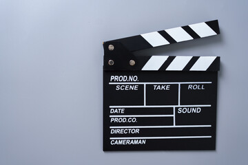 Fototapeta premium Black and white movie clapperboard on gray background, concept for filmmaking, video production, movie industry, creativity, media content, and cinematic storytelling.
