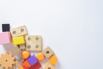 Colorful wooden toy blocks in various shapes on white background, concept for childhood education, learning, creativity, Montessori play, and preschool development.