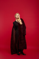 Naklejka premium Stylish winter fashion featuring a young woman in a vibrant red fur coat