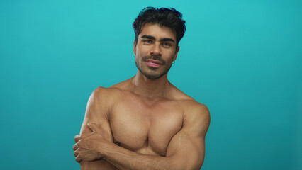 Fototapeta premium Man with closed eyes hugging his muscular chest with toned arms in studio and gentle smile; serenity.