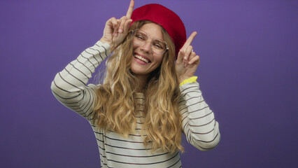 Woman holds fingers pointing towards ceiling in a studio setting, showcasing blonde hair, looking...