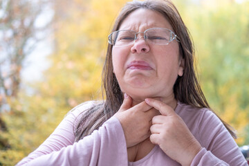 Adult woman indicating health problem in throat area, Female with neck pain, sore throat, hoarse...