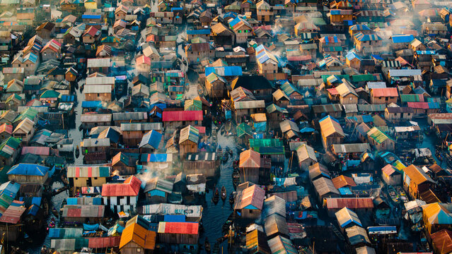 Aerial view of a sprawling settlement with vibrant rooftops nestled amidst waterways, a tapestry of life unfolding from above, Lagos, Lagos, Nigeria.