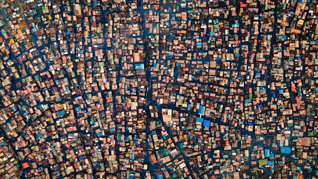 Aerial view of tightly packed buildings create a maze of colorful rooftops, reflecting the vibrant life below in this sprawling cityscape, Lagos, Lagos, Nigeria.