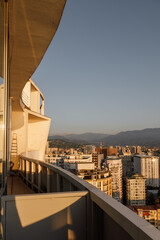 A Breathtaking Urban Skyline at Sunset with Majestic Mountains in the Background
