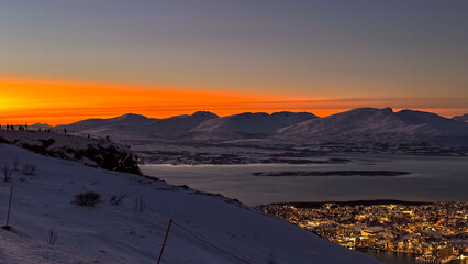 Sunset in the mountains  with panoramic night city view in Tromso. Norway