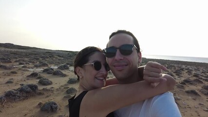 Happily married couple feeling love in nature. The young couple hugs and kisses each other and feels the wind on their skin.