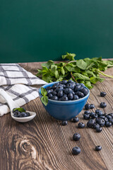 Autumn still life with blueberries on a black felt background and a cherry wood spoon with reddish tones