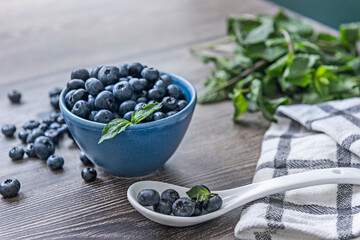 Family-grown blueberries on an aged chestnut wood background and a distinctive antique pewter spoon