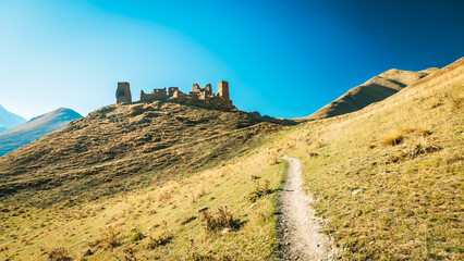Ancient stone fortress on a sunlit hill at the end of Truso Valley, Georgia. Majestic Caucasus...